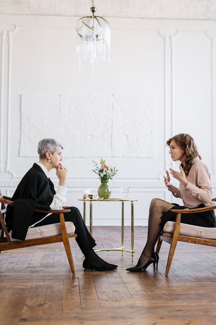 creative Two women engaged in a counseling session in a bright, modern loft setting.